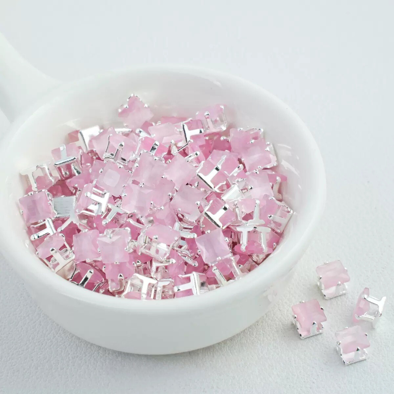 Precision-cut cat eye pink square CZ in silver-plated prong settings