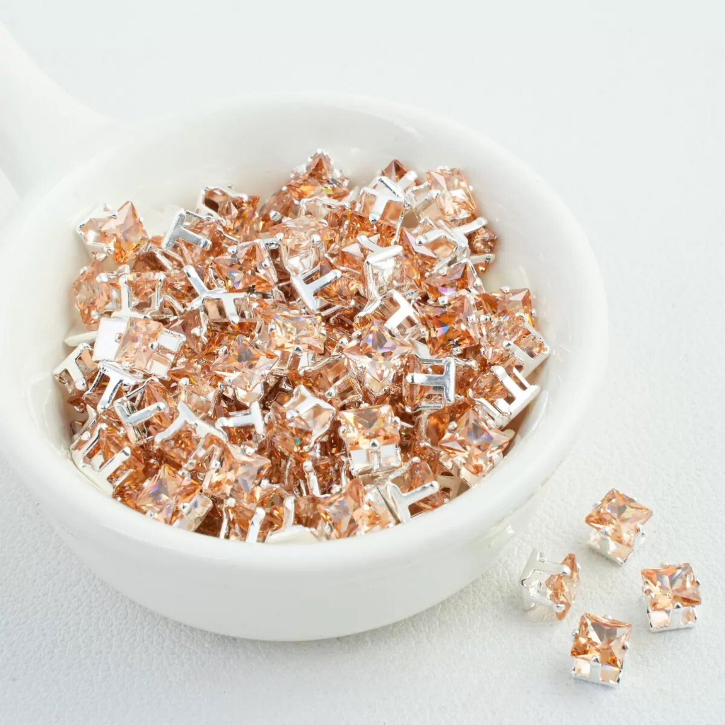 Precision-cut champagne square CZ in silver-plated prong settings
