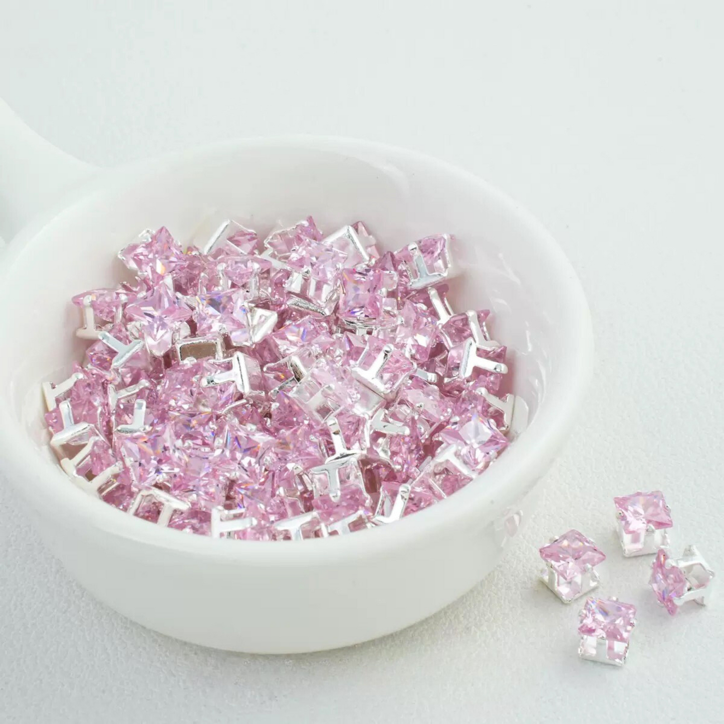 Precision-cut pink quare CZ in silver-plated prong settings