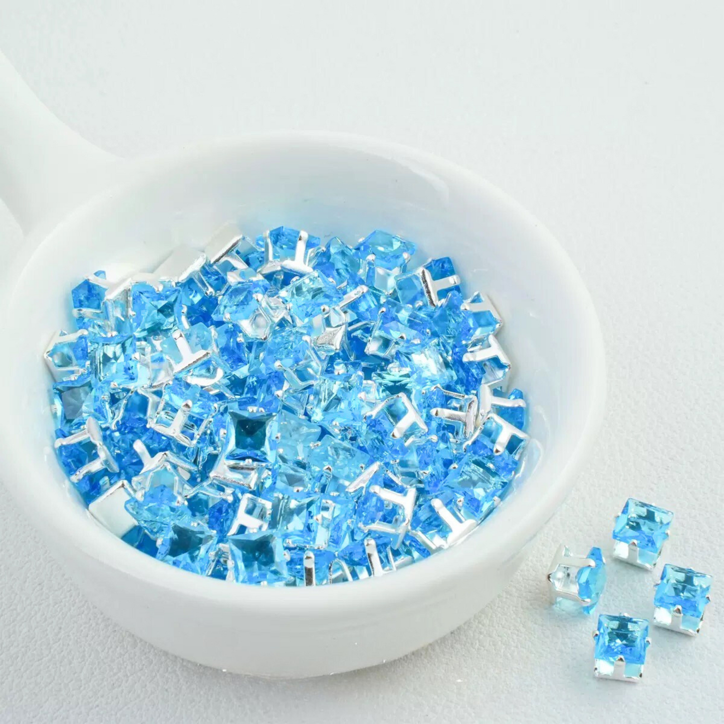 Precision-cut sky blue square CZ in silver-plated prong settings